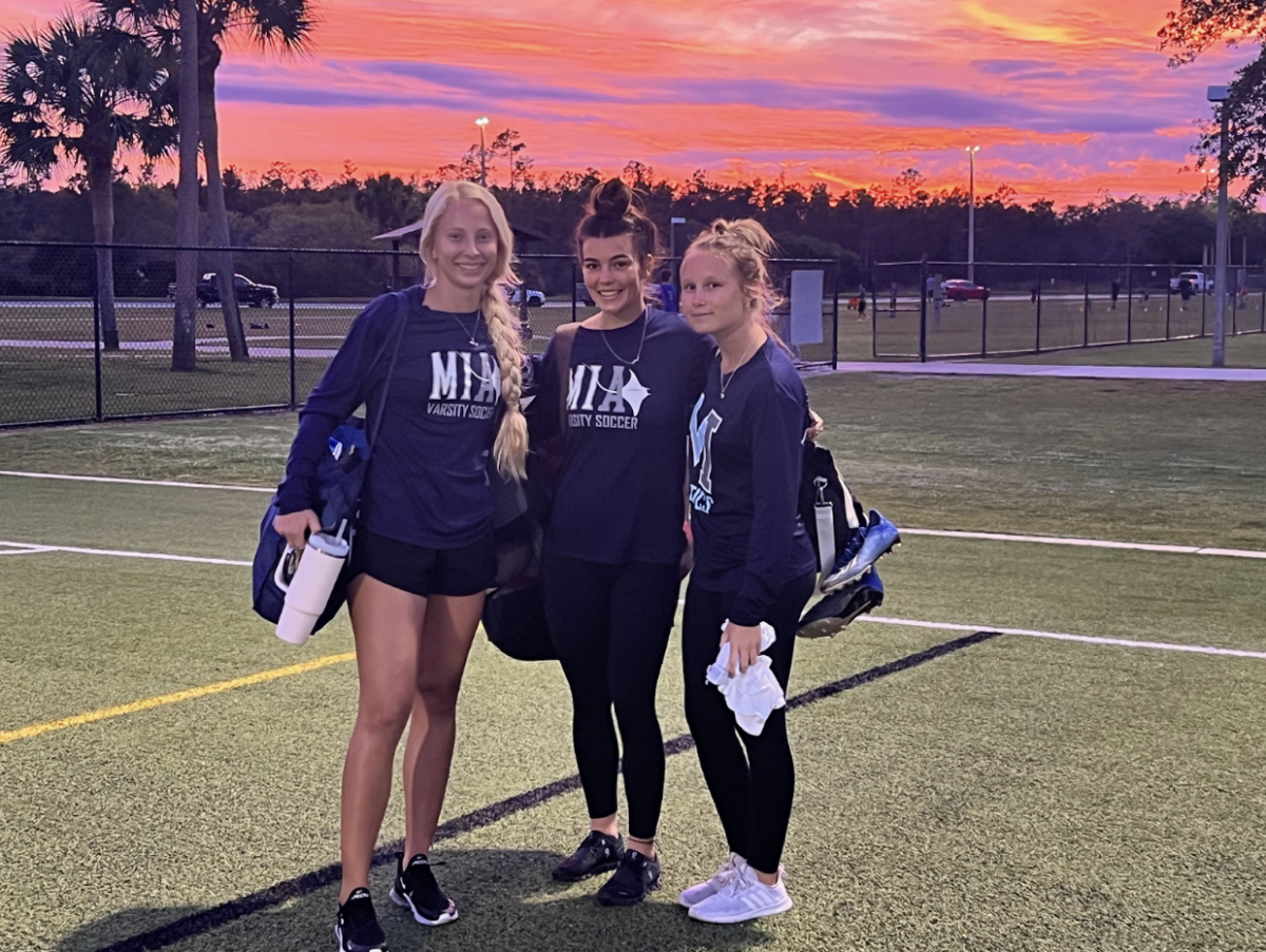 Coach Jax Wantlin (left), Savannah Heimerl (middle), and Hailey Cartwright (right) on MIAs soccer field. 